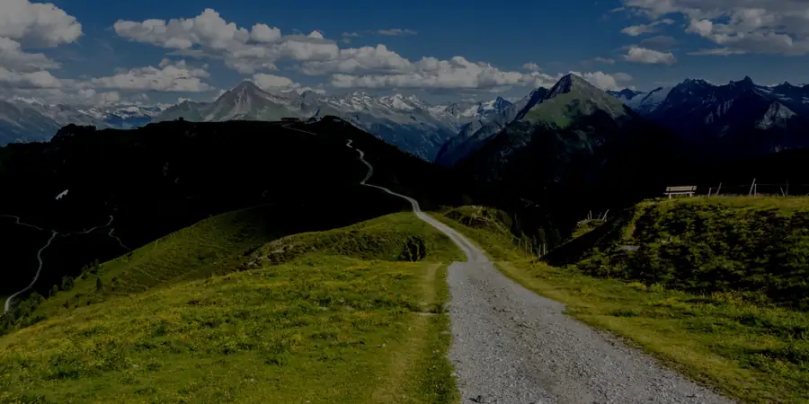 A gravel trail running along a green mountain ridge, the journey imagery the practice uses.