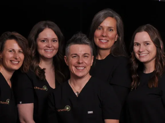 Dr. Charette with the four members of the Charette Prosthodontics team, in black practice scrubs.
